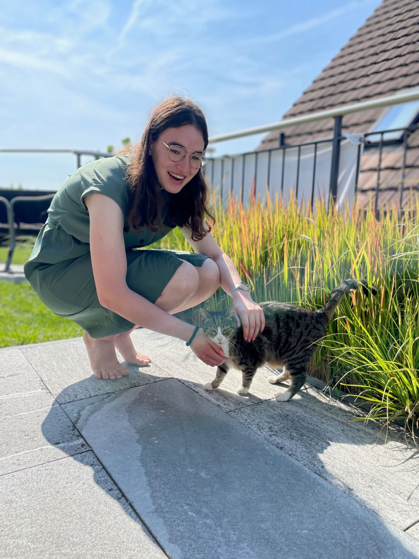 Eine junge Frau streichelt eine Katze.